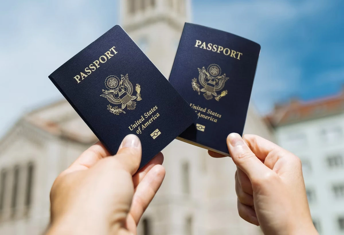 Two colleagues holding passports in front of an office building, symbolizing legal work abroad