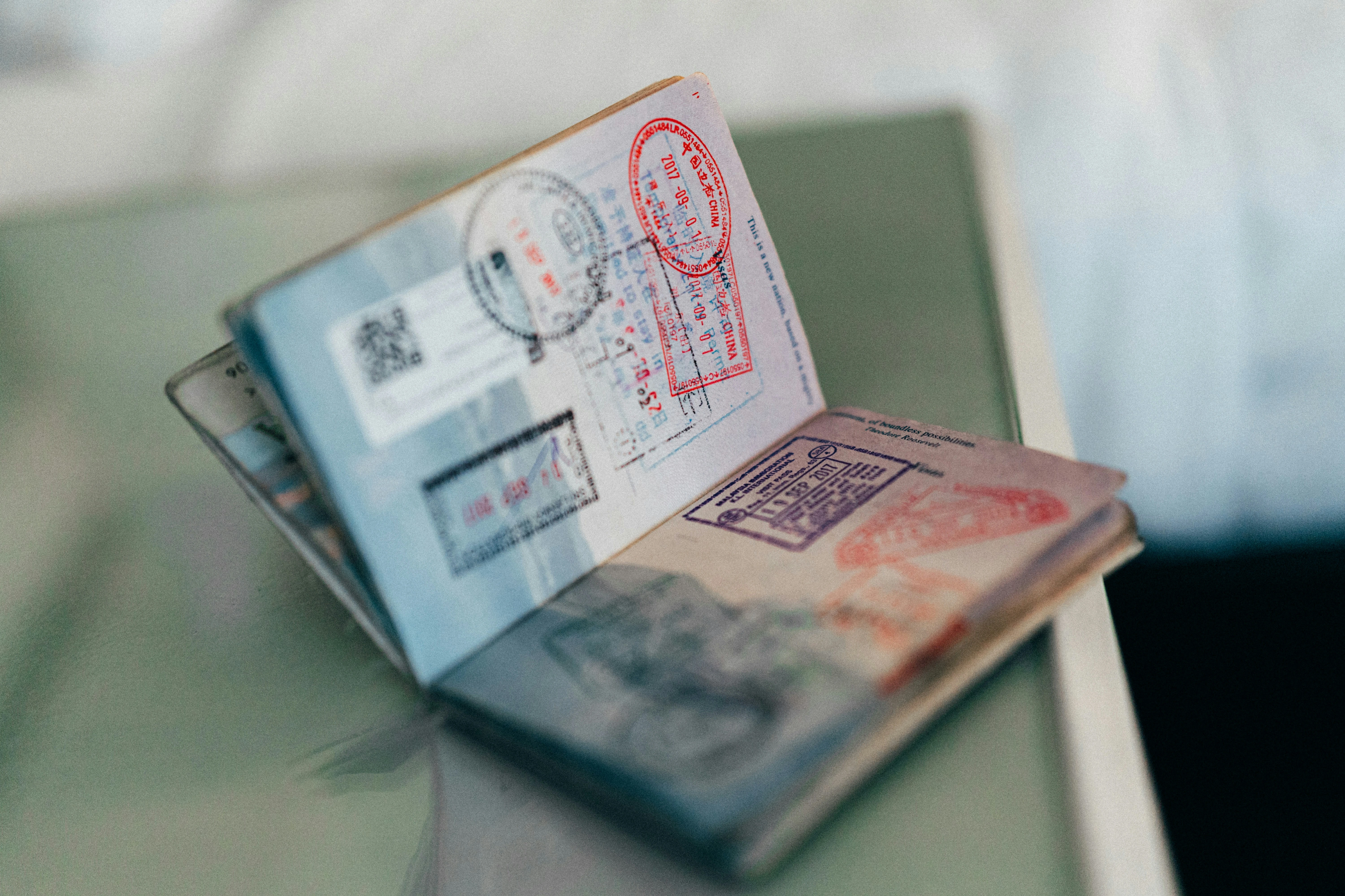 Open passport with multiple colourful entry and exit stamps